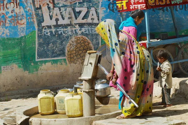 印度乌克哈 2007年3月27日 印度乌卡街道上的不明妇女用手泵将水抽到塑料容器 — 图库照片