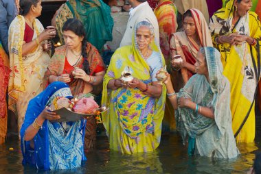 Varanasi, Hindistan - 25 Mart 2007: Kimliği belirsiz kadın hacılar dua, gündoğumu, kutsal Ganj Nehri Varanasi, Hindistan.