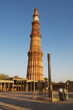Delhi, Hindistan - Mart 23, 2007: Kumtaşı Kulesi ve demir ayağı Qutb Minar Delhi, Hindistan karmaşık, kimliği belirsiz kişi ziyaret.
