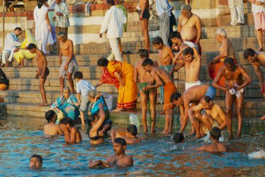 Varanasi, Hindistan - 25 Mart 2007: Tanımlanamayan hacılar yıkanmak kutsal Ganj Nehri içinde gündoğumu, Varanasi, Hindistan.