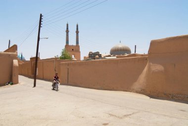 Yazd, Iran - Haziran 17, 2007: Kimliği belirsiz Yezd, İran'ın tarihi bölümünde kil kaplı duvarlı street tarafından Motosiklet sürmek.