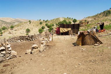 Yasuc, Iran - Haziran 21, 2007: Bahtiyari göçebe kampı Yasuc, Iran yakınındaki dağlarda. İran'ın bazı Bahtiyari insanlar hala göçebe yaşam tarzı takip, çadırlarda yaşamak ve günlük geleneksel elbise giymek.