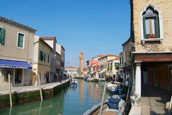 Vista al canal, barcos, edificios y personas en la calle a principios de primavera en Murano, Italia . — Foto de Stock