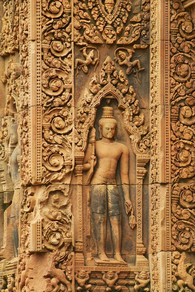 Pískovcové vyřezávání na stěně starověkého chrámu Banteay Srei v Kambodži v Siem sklízí. — Stock fotografie