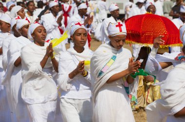 Addis Ababa, Etiyopya - 19 Ocak 2010: Beyaz elbise giyen genç Etiyopyalı bayanlar Addis Ababa, Etiyopya sokakta Timkat dini Ortodoks festivali kutlayan alayı katılmak.