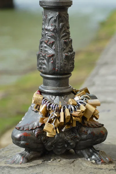 Symbol miłosny kłódki podłączane do słupa lampy ulicznej na brzegu rzeki Arno we Florencji, Włochy. — Zdjęcie stockowe