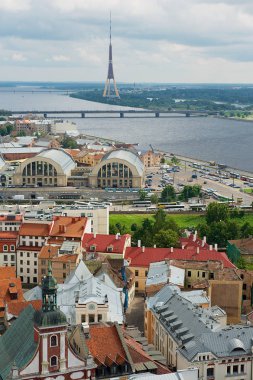 Riga, Letonya - 04 Ağustos 2009: Riga şehrindeki St. Peter kilisesinden eski şehir binalarının ve Daugava nehri karşısındaki köprünün panoraması.