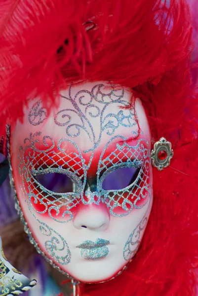 Gros plan sur les masques typiques du carnaval vénitien avec des plumes rouge vif . — Photo