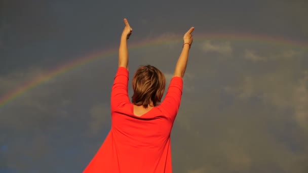 Mujer que muestra sus pulgares y firma la paz en el cielo durante el arco iris — Vídeos de Stock