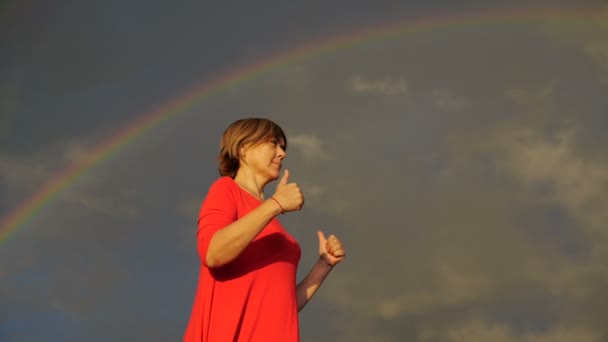Middelste leeftijd vrouw Toon duimen en glimlach tijdens de regenboog. — Stockvideo
