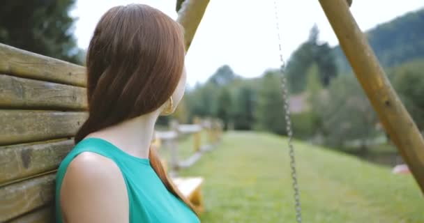 Young girl sitting and resting on the swing bench. — Stock Video