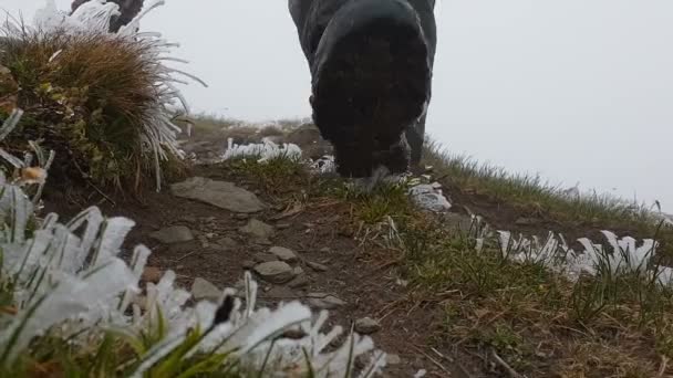 Close-up shot van de schoen van reiziger in de bergen bij de besneeuwde weer. — Stockvideo