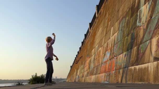 Jolly άνθρωπος ρίχνει μια μπάλα σε έναν τοίχο τράπεζα Ποταμός στην slo-mo — Αρχείο Βίντεο