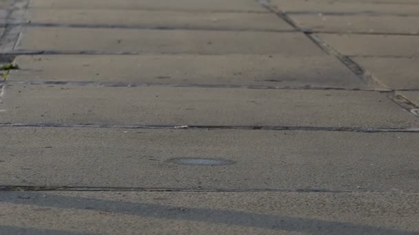 A concrete sidewalk and a jumping tennis ball on it in slo-mo — Stock Video