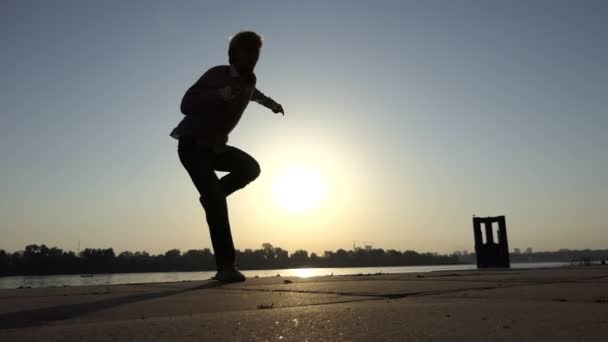 Ξανθός άντρας χορεύει ντίσκο ενεργά σε μια όχθη ποταμού στο slo-mo — Αρχείο Βίντεο
