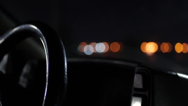 Il volante dell'auto alla luce delle luci notturne . — Video Stock