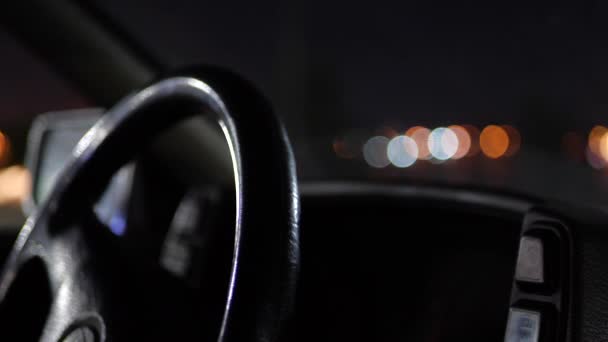 Het stuur van de auto in het licht van de nachtverlichting. — Stockvideo