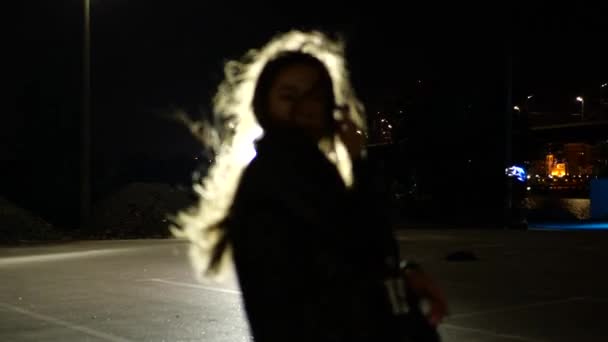 Mädchen tanzt für Videoclip im Scheinwerferlicht auf der Straße.