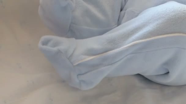 Lindas patitas de bebé en mono azul . — Vídeo de stock