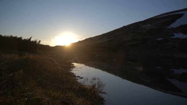 Záhadné jezero s kopcovitý pobřežím na podzim v třpytivý západ slunce — Stock video