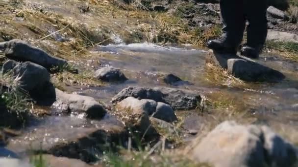 Pequenos pés femininos em botas cruzando um córrego de montanha nos Cárpatos em slo-mo — Vídeo de Stock