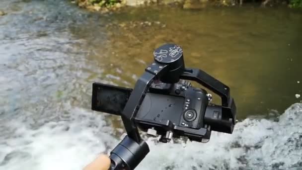 Mirrorless camera with electronical gimbal shooting waterfall in slow motion. — Stock Video