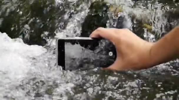 Vidéo au ralenti de la main qui fait la vidéo de l'eau dans le flux d'eau . — Video