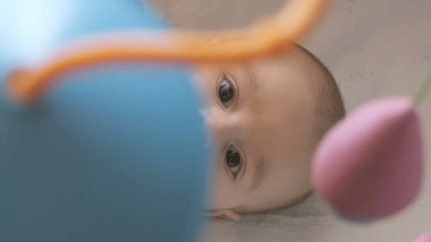Kleines Kind mit neugieriger Miene schaut auf sein Spielzeug — Stockvideo
