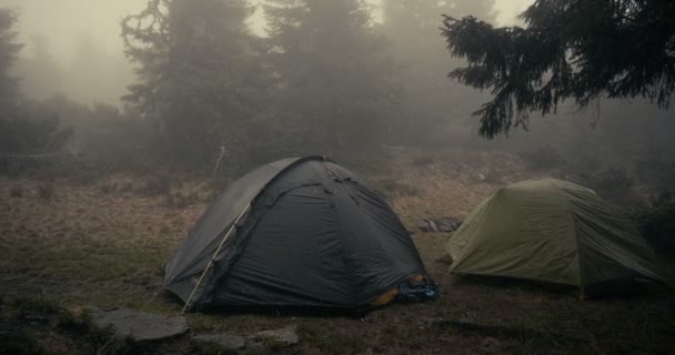 Dwa kuliste namioty pod opadającym mokrym śniegiem w Karpatach jesienią w SLO-mo — Wideo stockowe