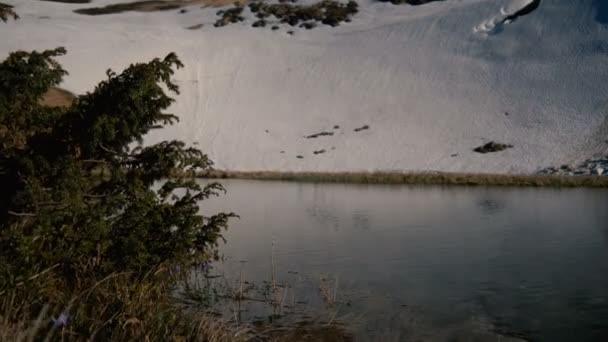 Горное озеро и снежный крутой склон в Карпатах в сло-мо — стоковое видео