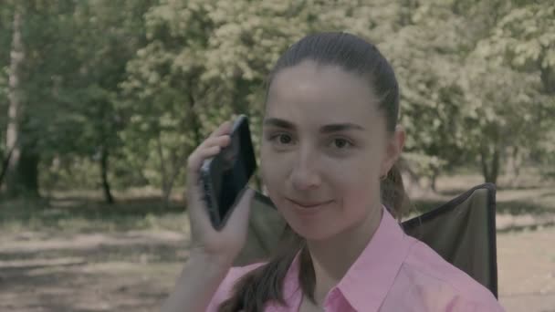 Девушка в лесу разговаривает по телефону . — стоковое видео