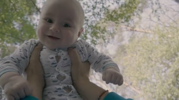 Söt liten bebis i händerna har ett leende på läpparna. — Stockvideo