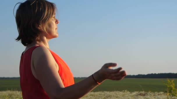 Mulher inspirada colocando as mãos em um gesto de oração e meditando em slo-mo — Vídeo de Stock