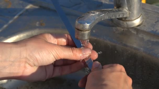 Mani femminili lavare un lungo spiedo metallico sopra lavello da cucina all'aperto in slo-mo — Video Stock