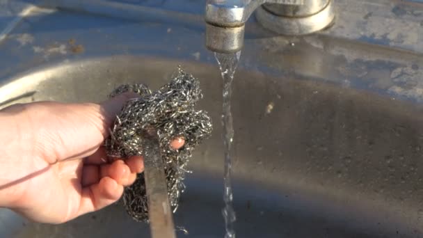 Long metallic skewer is washed with a fluffy metallic wisp outdoors in slo-mo — Stock Video