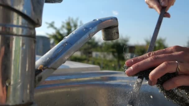 Vrouwelijke handen wassen van een lange Spies over een tuin wastafel in de zomer in slo-mo — Stockvideo