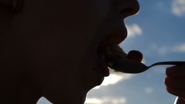 Joven boca de mujer está tomando una cuchara con una fresa al aire libre en slomo — Vídeos de Stock