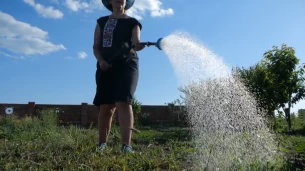 Glückliche Frau in Panama bewässert ein Gartenpflaster aus einem Duschkopf in slo-mo — Stockvideo