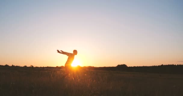 Homme optimiste sautant et montrant les gestes du pouce vers le haut au coucher du soleil à Xo@-@ mo — Video