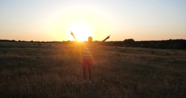 Legrační člověk v kraťasech tance a zobrazující číslo 1 gesta při západu slunce v slo-mo — Stock video