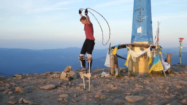 Mann springt auf Stelzen durch Springseil am Goverla-Berg. — Stockvideo