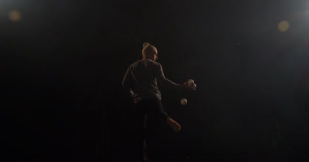 Ein stilvoller Jongleur auf der Bühne wirft den Ball mit dem Bein an den Arm. Nein. — Stockvideo