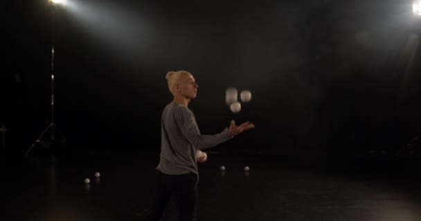 4k - Жонглер в черной студии делает трюки с пятью шарами . — стоковое видео