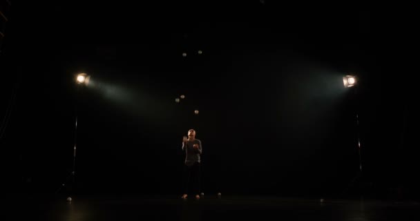 Zsonglőr a színpadon teszi trükkök a 7 labdát, és egy nem. — Stock videók
