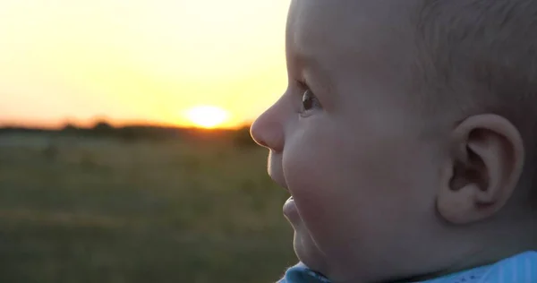 夕暮れ時に彼の母親を見ながら面白い赤ちゃんの笑顔 — ストック写真