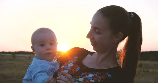 Счастливая малышка и ее ребенок бледнеют друг с другом в поле на закате — стоковое фото