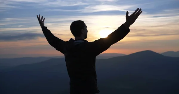 Man on the top of the world at sunset spread his arms. Stock Picture