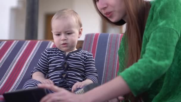 Baby pojken tittar på en video på telefonen och är förbandra — Stockvideo