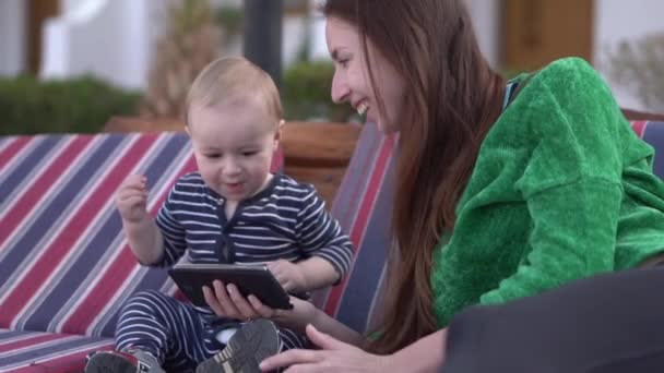 Mamma och baby tittar glatt på videor på sin smartphone och dans — Stockvideo