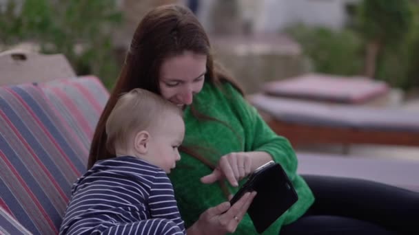 Bebê relógios como mãe clica no menu do smartphone em câmera lenta — Vídeo de Stock